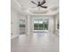 Bright, open living room with tile floors, ceiling fan, and a view of the landscaped backyard at 13524 Circa Crossing Dr, Lithia, FL 33547