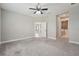 Carpeted main bedroom with a ceiling fan and doorway leading to en-suite bathroom at 13524 Circa Crossing Dr, Lithia, FL 33547