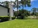 Exterior view featuring green lawn, trees, shrubbery and view of pond at 140 Nina Way, Oldsmar, FL 34677