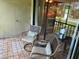 Relaxing screened-in balcony with tiled floor, comfortable seating, and serene outdoor view at 140 Nina Way, Oldsmar, FL 34677