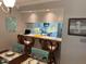 Stylish dining area with bar seating, connecting to a bright kitchen with modern appliances and ample counter space at 140 Nina Way, Oldsmar, FL 34677