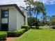 Landscaped condo with a manicured lawn and trimmed hedges at 140 Nina Way, Oldsmar, FL 34677
