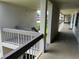 The exterior hallway features a painted grey railing and concrete flooring at 140 Nina Way, Oldsmar, FL 34677