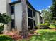 Townhouse with a screened in porch surrounded by mature landscaping at 140 Nina Way, Oldsmar, FL 34677