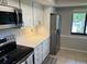 Well-equipped kitchen with stainless steel appliances, white cabinetry, and a convenient window for natural light at 140 Nina Way, Oldsmar, FL 34677