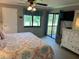 Bedroom features a ceiling fan, dresser, and a sliding glass door that leads to the balcony at 140 Nina Way, Oldsmar, FL 34677