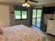 Bedroom features a ceiling fan, dresser, and a sliding glass door that leads to the balcony at 140 Nina Way, Oldsmar, FL 34677