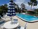 Community pool with seating, umbrellas and a view of the neighborhood at 140 Nina Way, Oldsmar, FL 34677