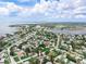 Drone shot offering a neighborhood view with homes amid lush trees and serene bay waters at 1580 Arizona Ave Ne, St Petersburg, FL 33703