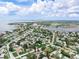 Drone shot offering a neighborhood view with homes amid lush trees and serene bay waters at 1580 Arizona Ave Ne, St Petersburg, FL 33703