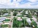 Aerial view of the property in a well-kept neighborhood with mature trees and lush landscaping, featuring a large grassy lot at 1580 Arizona Ave Ne, St Petersburg, FL 33703