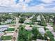 Aerial view of the property in a well-kept neighborhood with mature trees and lush landscaping, featuring a large grassy lot at 1580 Arizona Ave Ne, St Petersburg, FL 33703