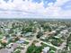 Spacious neighborhood featuring well-maintained homes with mature trees and landscaping under blue skies with fair weather clouds at 1580 Arizona Ave Ne, St Petersburg, FL 33703