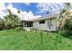 Home exterior featuring a screened-in porch and lush greenery, blending indoor/outdoor living at 1580 Arizona Ave Ne, St Petersburg, FL 33703