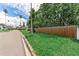 Street view showcasing a wooden fence lining the property with lush green grass and palm trees at 1580 Arizona Ave Ne, St Petersburg, FL 33703
