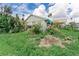 Shows a grassy yard with minimal landscaping and a building with white siding on a sunny day at 1580 Arizona Ave Ne, St Petersburg, FL 33703