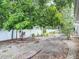 Landscaped backyard with white fence and mature trees provide privacy and shade at 1607 New Bedford Dr, Sun City Center, FL 33573