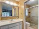 Bathroom featuring a vanity with a decorative mirror and a walk-in shower with glass doors at 1607 New Bedford Dr, Sun City Center, FL 33573