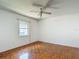 Bedroom with parquet wood floors, a ceiling fan and a window providing natural light at 1607 New Bedford Dr, Sun City Center, FL 33573