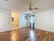 Bedroom with wood-look floors, ceiling fan, and view into the adjacent bathroom at 1607 New Bedford Dr, Sun City Center, FL 33573