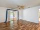 Bedroom with wood-look floors, ceiling fan, and sliding glass doors leading to the backyard at 1607 New Bedford Dr, Sun City Center, FL 33573