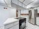 A stylish kitchen featuring an island with a cooktop, white cabinets, and stainless steel appliances at 1607 New Bedford Dr, Sun City Center, FL 33573