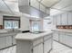 Bright kitchen with white cabinets, a central island cooktop, and sliding door access to the backyard at 1607 New Bedford Dr, Sun City Center, FL 33573