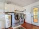 Laundry room with washer and dryer, water heater and overhead storage cabinets at 1607 New Bedford Dr, Sun City Center, FL 33573