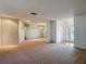 Expansive living area featuring neutral carpeting, access to multiple rooms, and abundant natural light, perfect for relaxation at 1607 New Bedford Dr, Sun City Center, FL 33573