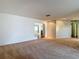 Cozy living room with neutral carpeting, white walls, and access to other rooms, offering versatile space for furnishings at 1607 New Bedford Dr, Sun City Center, FL 33573