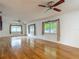 Bright living room with hardwood floors, ceiling fans, and large windows dressed with curtains, creating a comfortable space at 1607 New Bedford Dr, Sun City Center, FL 33573