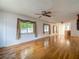 Bright living room featuring hardwood floors, white walls, and plenty of natural light from the large windows at 1607 New Bedford Dr, Sun City Center, FL 33573