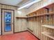Storage room with red tile floors, wood paneling and shelving for storage at 1607 New Bedford Dr, Sun City Center, FL 33573