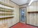 Storage room featuring red tile floors, wood paneling and lots of shelving at 1607 New Bedford Dr, Sun City Center, FL 33573