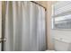 Bathroom featuring a standard toilet and shower with a window at 17701 Sunrise Dr, Lutz, FL 33549