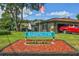 A well-maintained community sign, 'Barrington,' with a lush lawn, flowers, and American flag at 17701 Sunrise Dr, Lutz, FL 33549