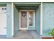Close-up of a home's front door, showing a wreath and the adjacent sidelight window and white doorframe at 17701 Sunrise Dr, Lutz, FL 33549