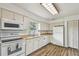 This bright kitchen features matching white appliances, wood countertops, and wood look floors at 17701 Sunrise Dr, Lutz, FL 33549