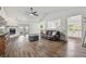 Bright living room with wood floors, a ceiling fan, a fireplace, and a comfortable leather sofa at 17701 Sunrise Dr, Lutz, FL 33549