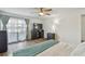 Large main bedroom featuring wood look floors, a ceiling fan, and a large window at 17701 Sunrise Dr, Lutz, FL 33549
