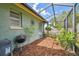 View of the screened in patio with seating area and landscaping at 17701 Sunrise Dr, Lutz, FL 33549