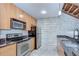 Well-equipped kitchen with stainless steel appliances, wooden cabinets, and granite countertops at 2001 E 2Nd Ave # 12, Tampa, FL 33605