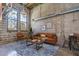 Comfortable living room boasts exposed brick walls, large windows, modern furnishings, and abundant natural light at 2001 E 2Nd Ave # 12, Tampa, FL 33605