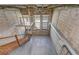 Open-concept living space with exposed brick, tall windows, and floating staircase at 2001 E 2Nd Ave # 12, Tampa, FL 33605