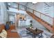 Stylish open-concept living room with stairs to loft, modern furniture, and exposed brick walls at 2001 E 2Nd Ave # 12, Tampa, FL 33605