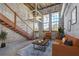 Inviting living room featuring exposed brick, high ceilings, wooden staircase, and industrial-chic design elements at 2001 E 2Nd Ave # 12, Tampa, FL 33605
