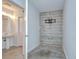 Room with a pedestal sink, exposed brick, and tv mount at 2001 E 2Nd Ave # 12, Tampa, FL 33605