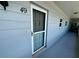 Condo entrance with a dark gray door, unit number 49, and small windows along the exterior wall at 2341 Haitian Dr # 49, Clearwater, FL 33763