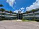 Exterior shot of a pale blue condominium complex with palm trees, parking, and a unique central dome at 2341 Haitian Dr # 49, Clearwater, FL 33763