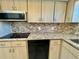 Kitchen area with light wood cabinets, granite countertops, and black appliances including a flat cooktop at 2341 Haitian Dr # 49, Clearwater, FL 33763